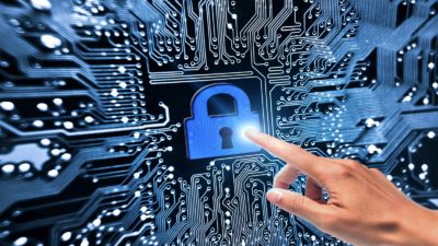 A hand pointing to security lock symbol on computer circuit board, indicating a share price movement for software security companies