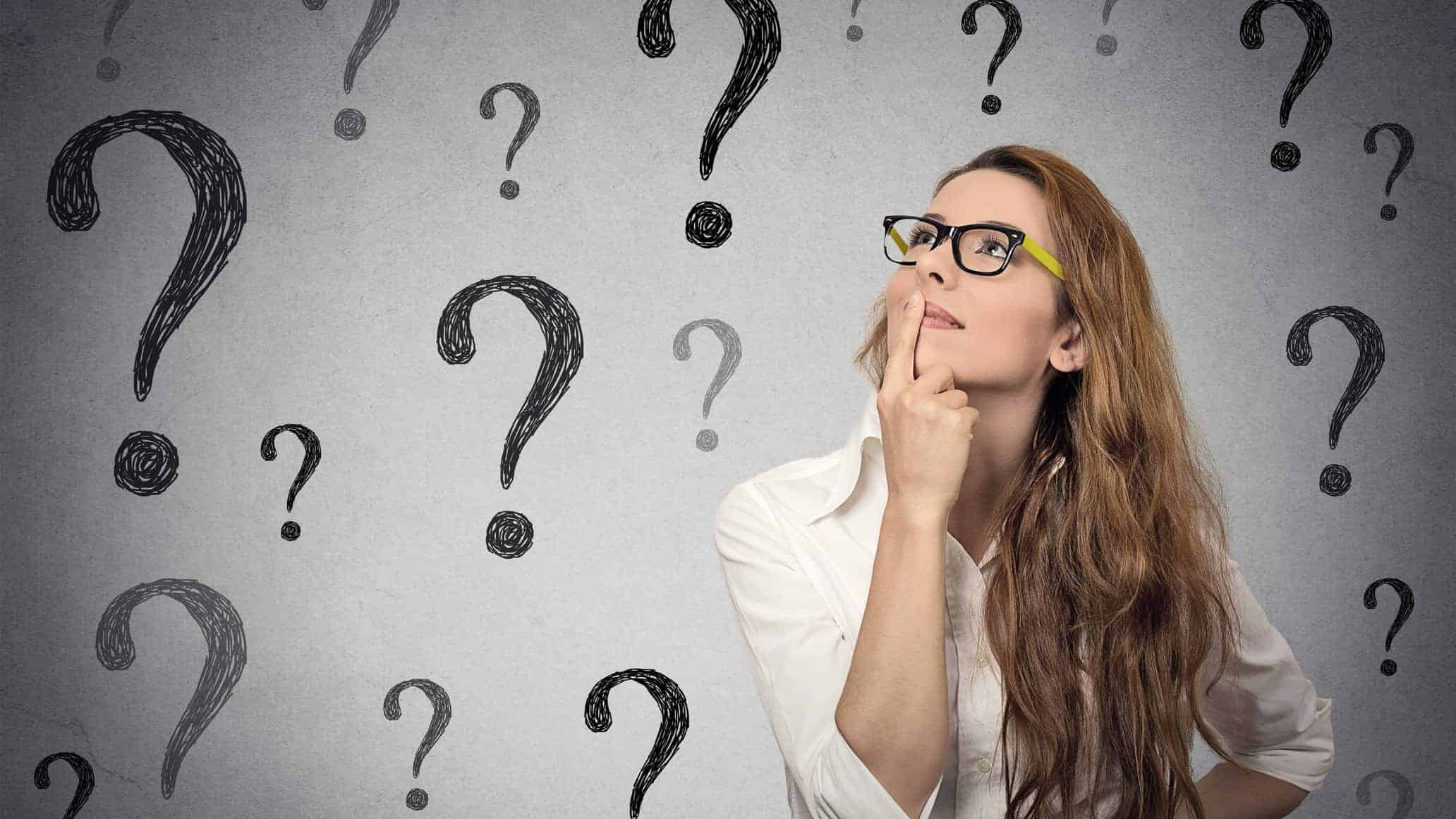 woman surrounded by question marks as if wondering about as share price