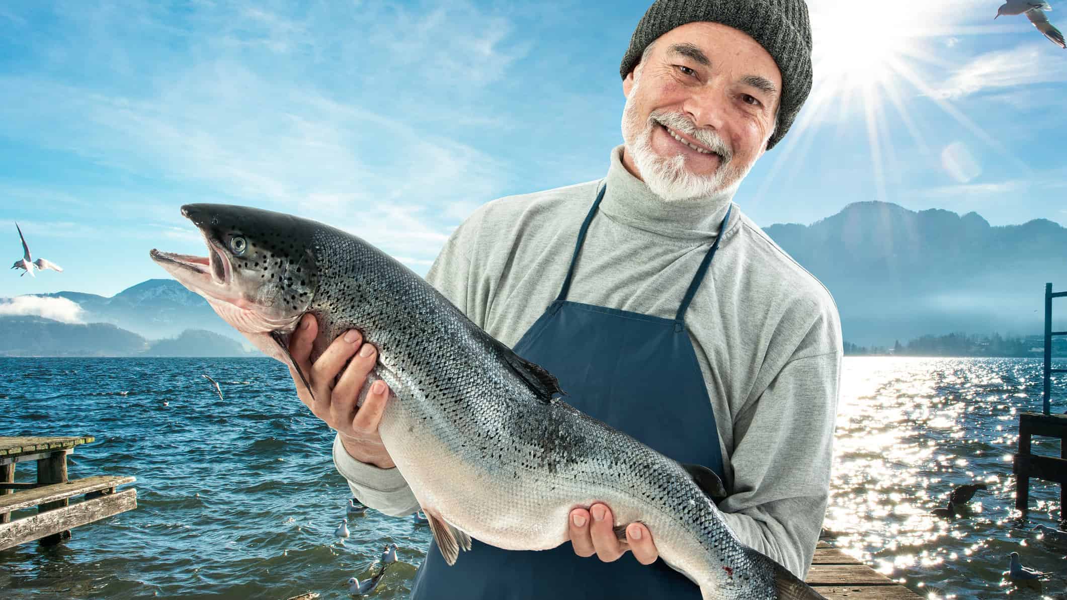 Salmon farmer holding large fish
