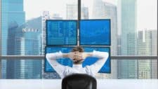 Broker trading shares relaxing looking at screen