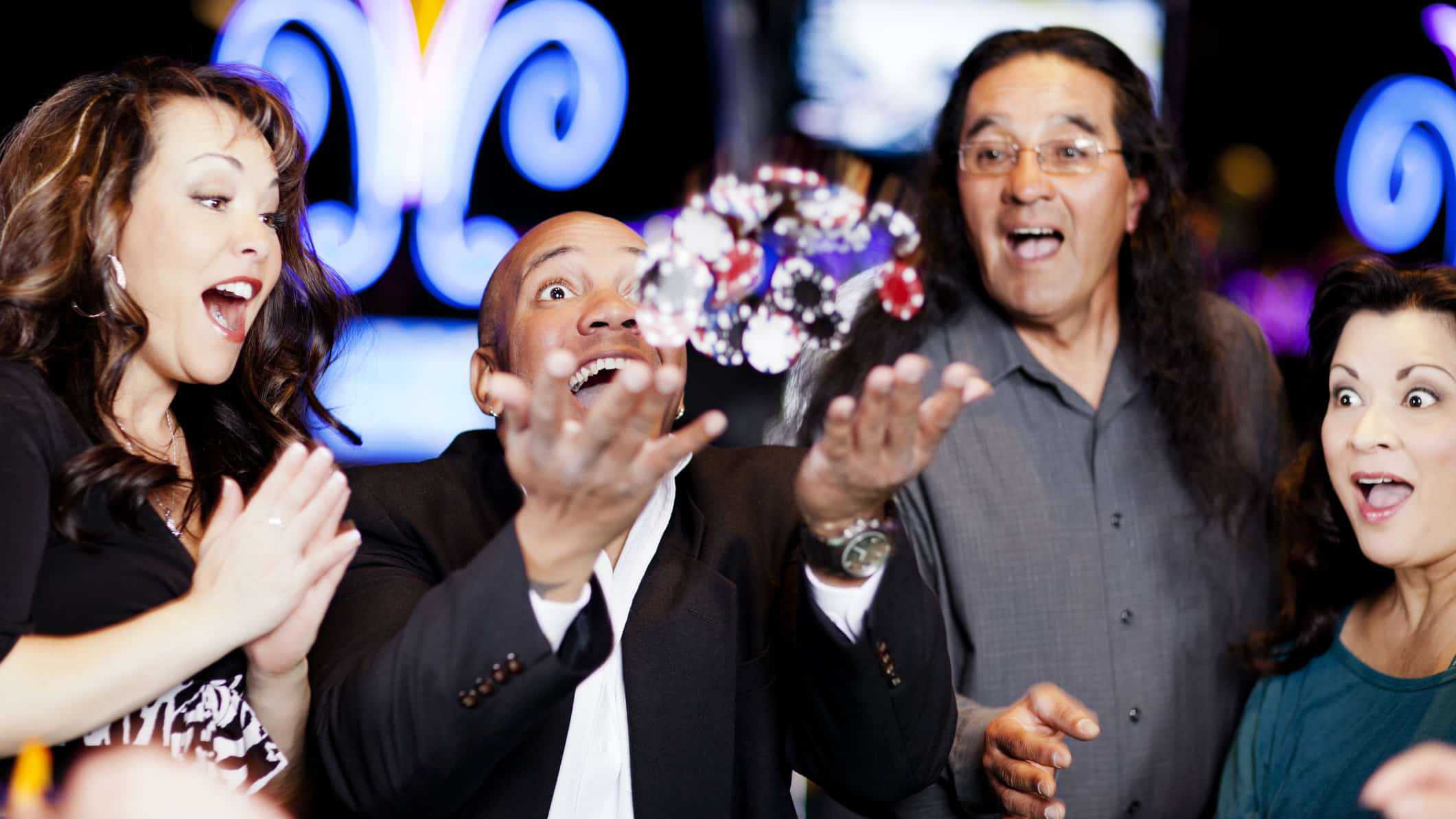 man at casino throwing chips in the air