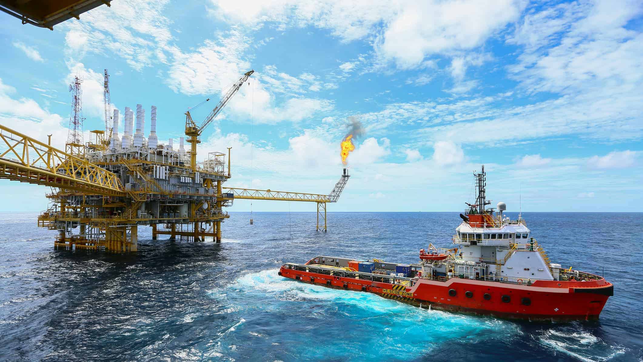 A Woodside oil rig and a boat in the middle of the ocean