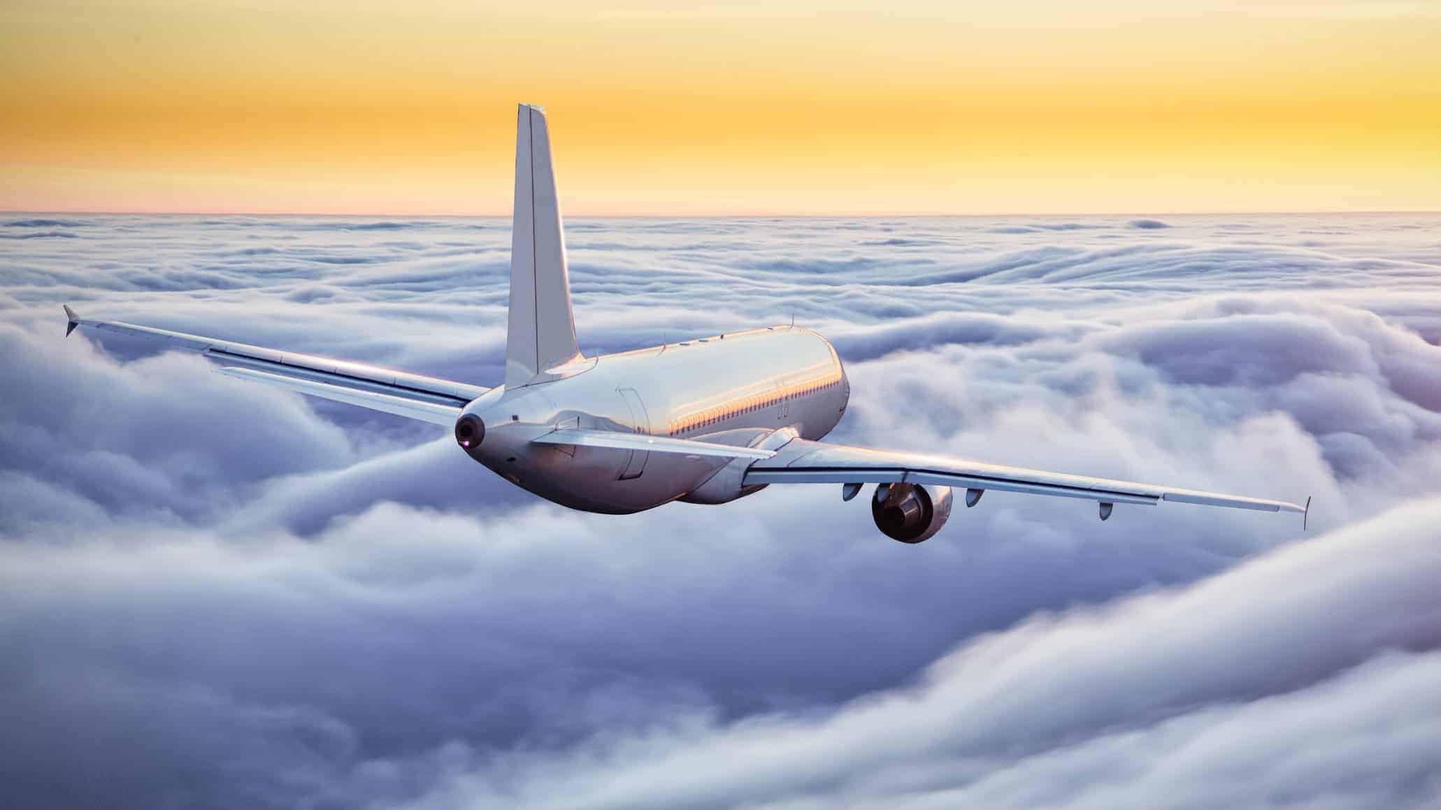 Qantas airplane in the sky amongst the clouds at sunset