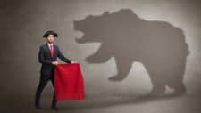 Broker holding red flag in front of bear