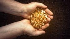 gold asx share price rise represented by hands holding pile of gold