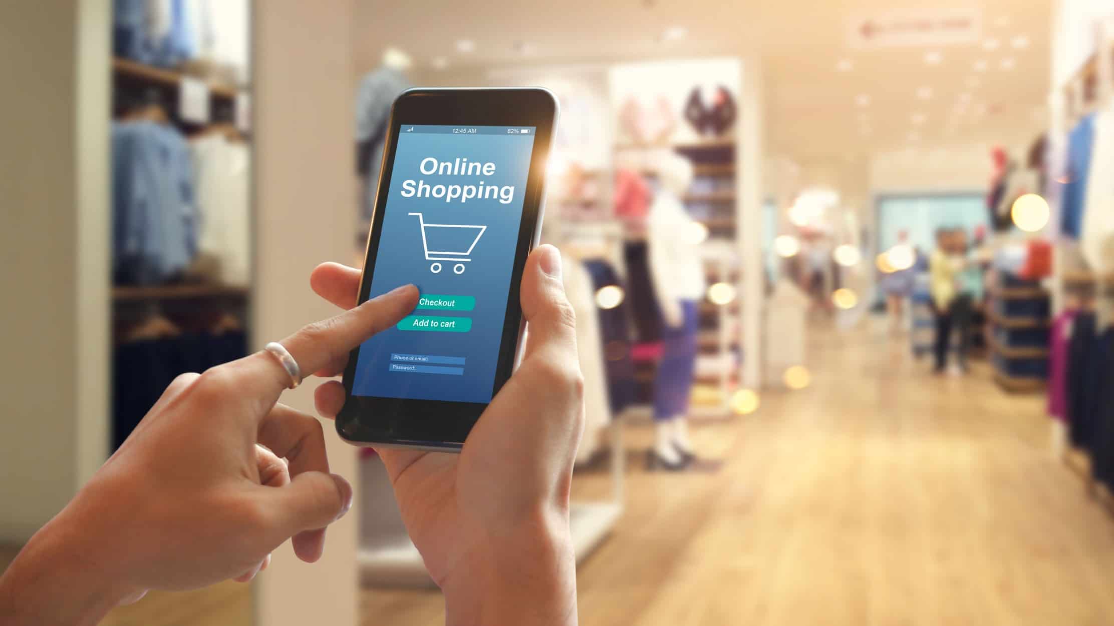 Holding smartphone with online shopping on screen