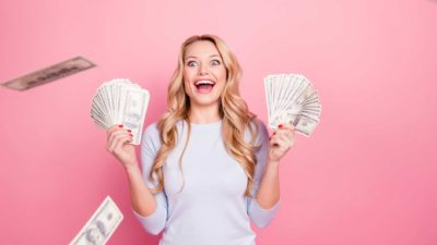 Woman holding up wads of cash