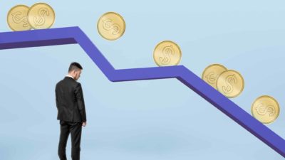 falling asx gold share price represented by businessman watching gold coins fall down