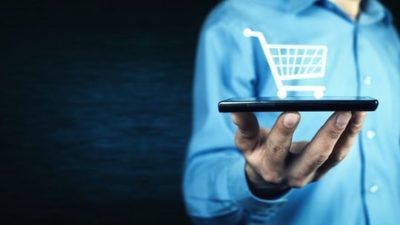 Man holding smartphone with shopping cart icon