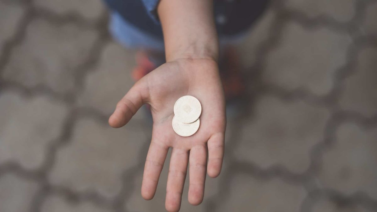 hand outstretched with two coins in palm