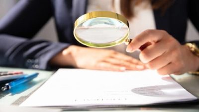 close up of magnifying glass over paperwork