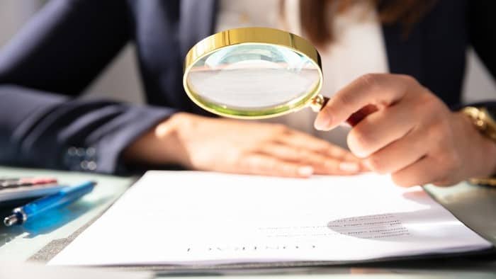 close up of magnifying glass over paperwork