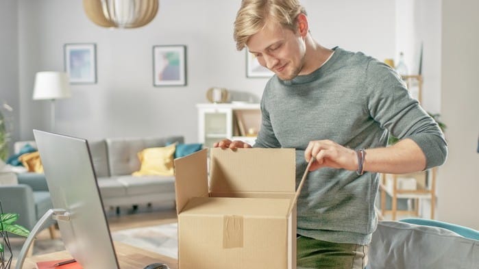 Man opening Walmart package in home office