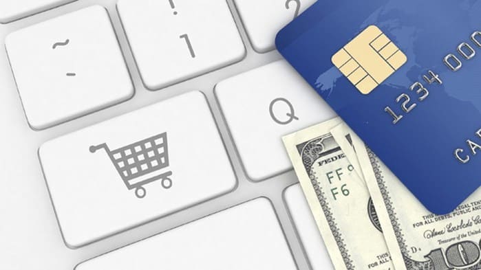 Closeup of a keyboard with a shopping trolley icon and a credit card