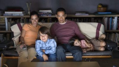 Family of four sitting on couch watching Netflix