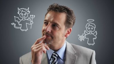 Man in suit considering the devil on his shoulder