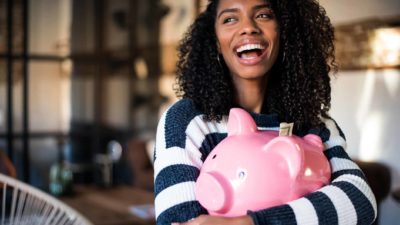 woman holding large pink piggy bank