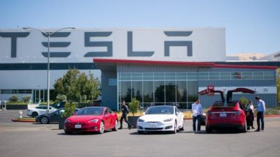 Tesla vehicles parked in front of Tesla building