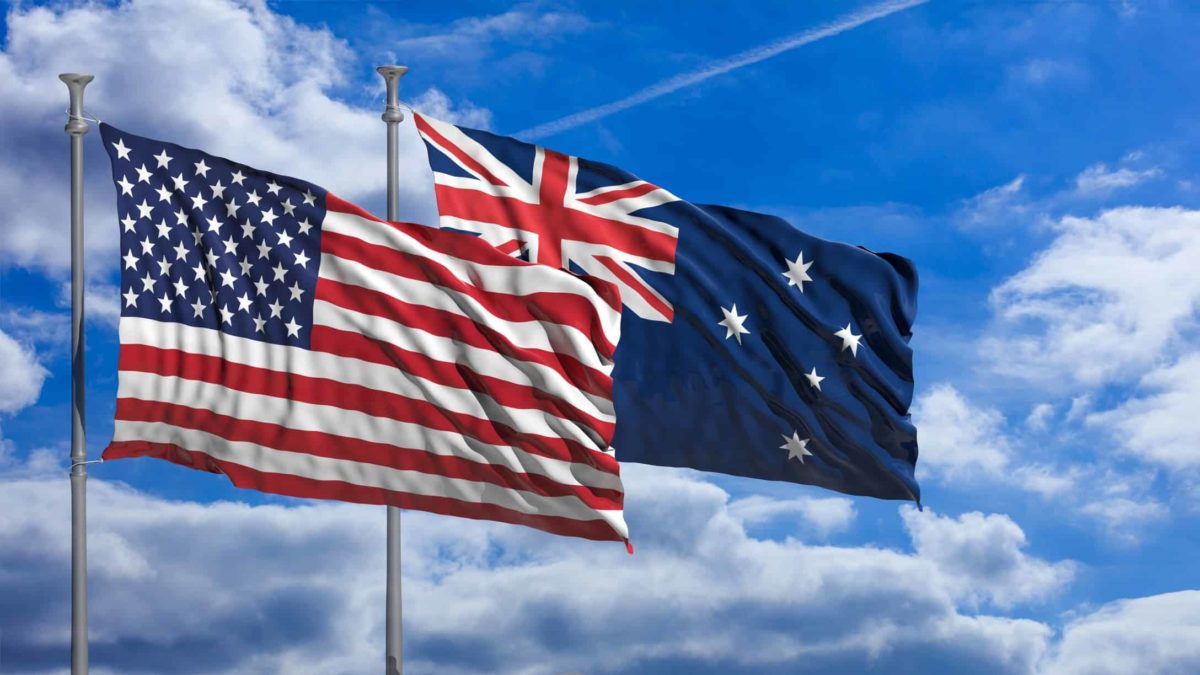 American and Australian flags flying against blue sky