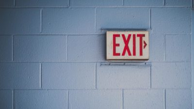 Red exit sign on brick wall