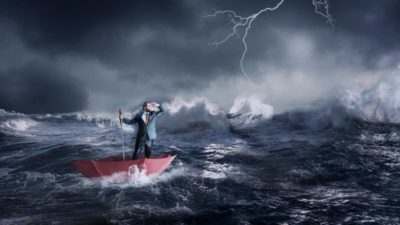 Rough seas in a storm with businessman standing in an umbrella Huon share price profit downgrade