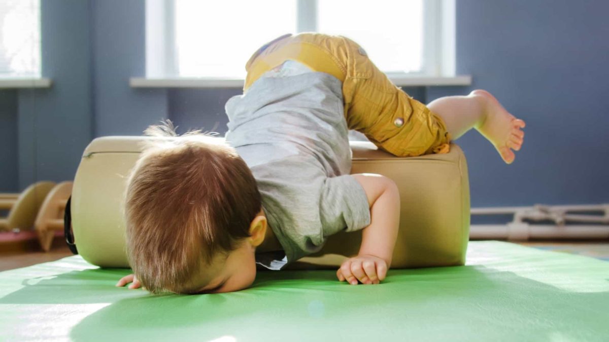 Falling ASX share price represented by toddler nosediving over cushion onto floor.