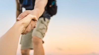 Man reaching down to help a friend up