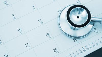 Monthly calendar page with stethoscope placed on top