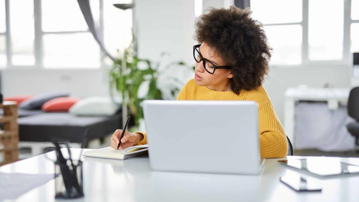 A young female investor sits at her desk researching small-cap ASX shares and wondering if there are any good bargains out there