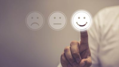 Man in white business shirt touches screen with happy smile symbol IGO share price upgrade