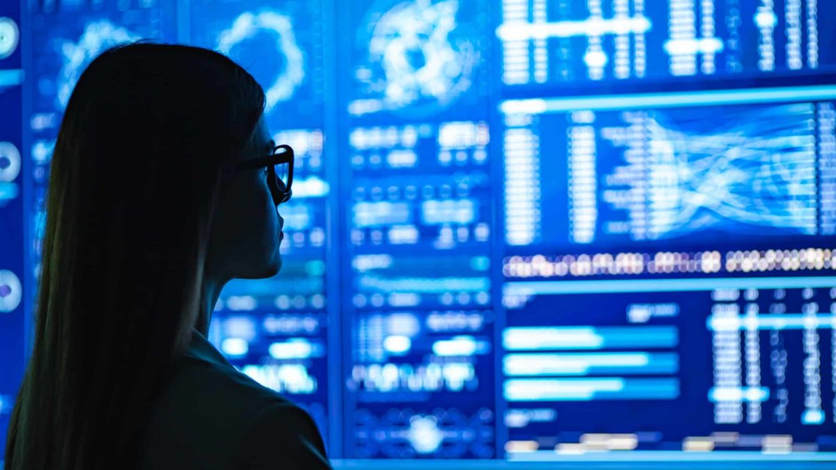 Female investor looking at a wall of share market charts