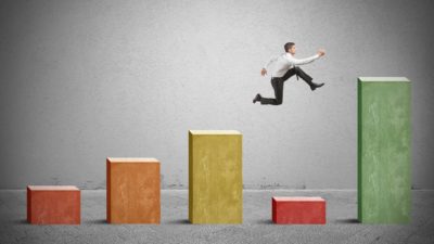 bar graph with man jumping over low number representing dip in asx shares