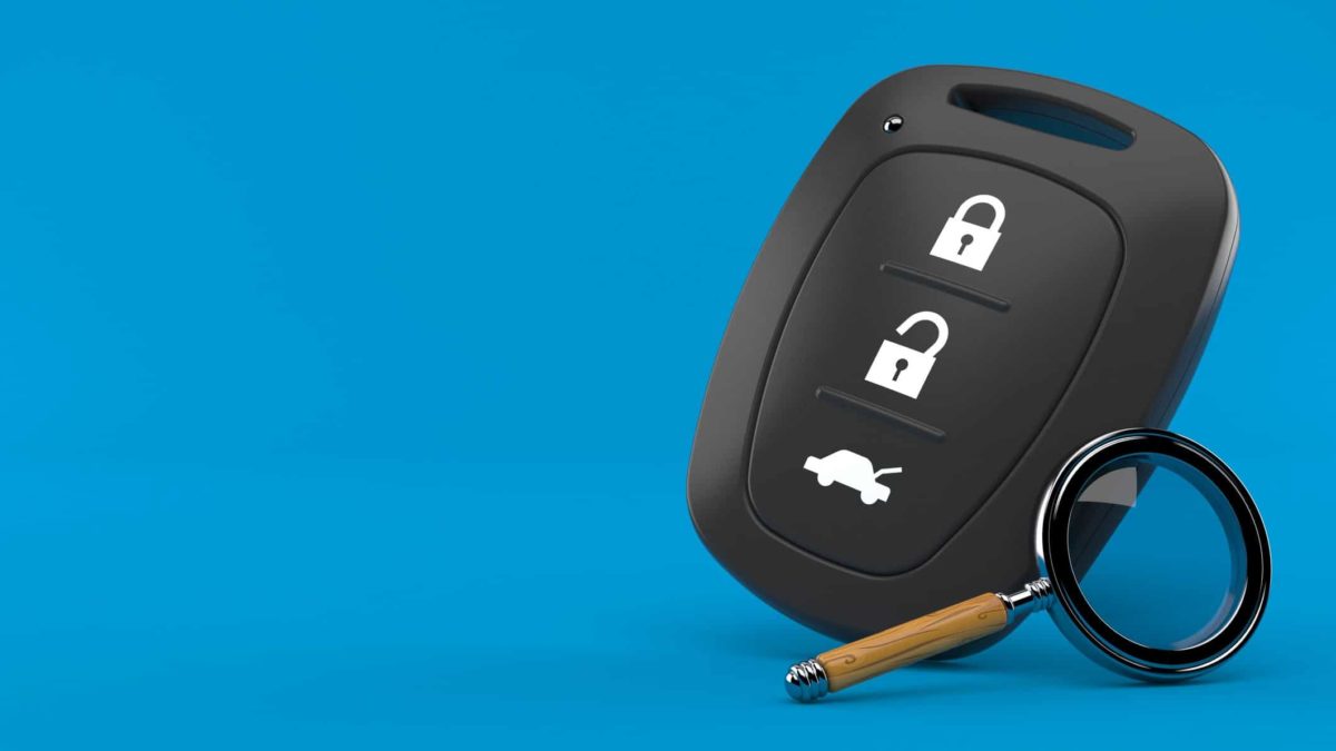 Car key and magnifying glass on blue background to signal car shares