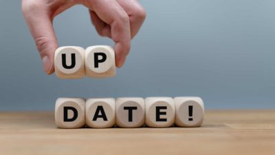 changing asx share price represented by hand arranging wooden blocks that spell update