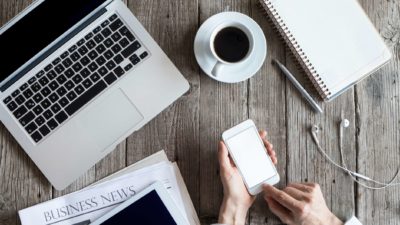 laptop, newspaper, ipad, coffee and hands holding iphone