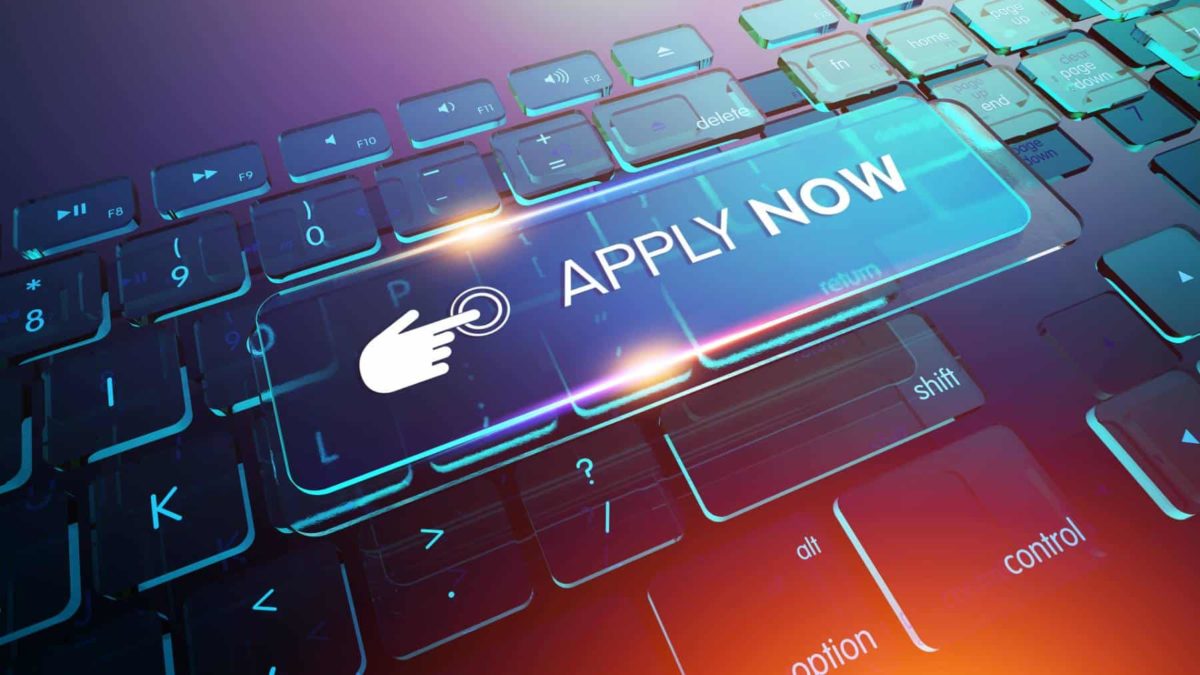 digital apply now button against backdrop of laptop keyboard