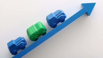rising asx share price represented by miniature cars driving along an upward pointing arrow