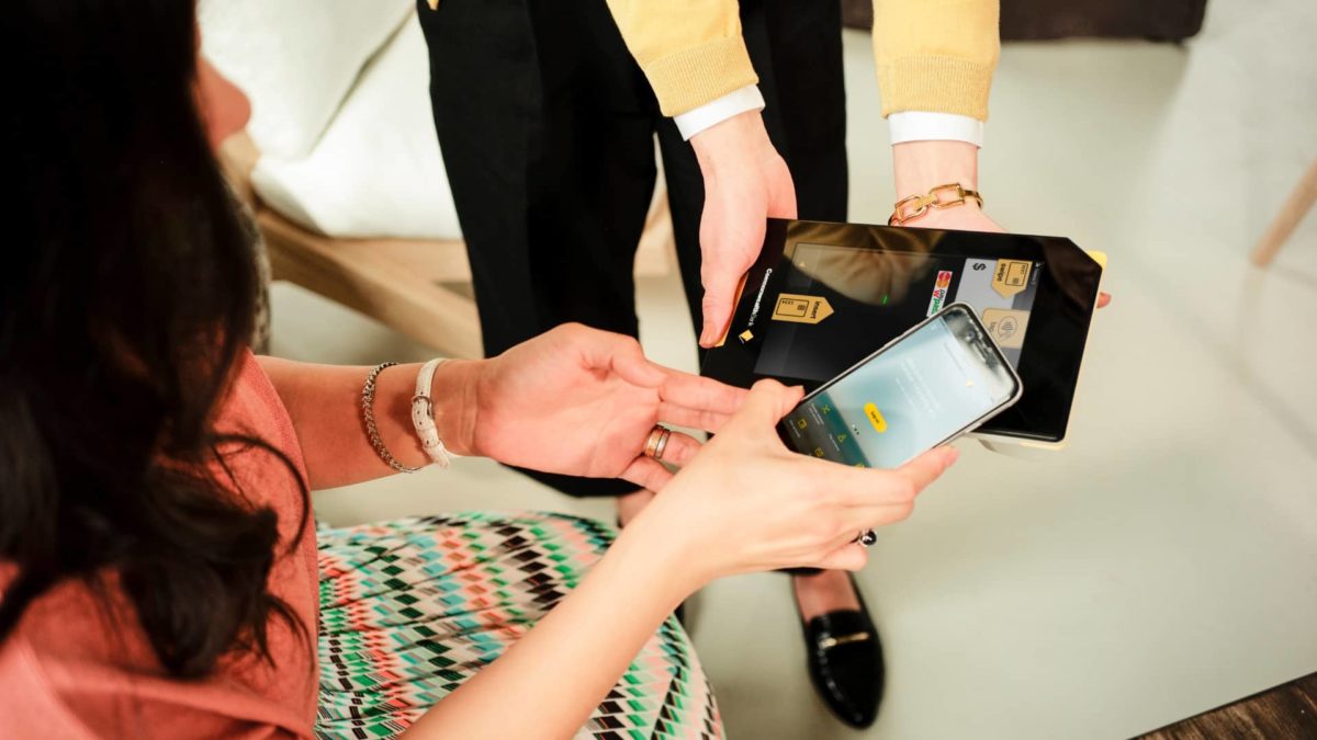 woman making digital payment using her iphone and cba albert