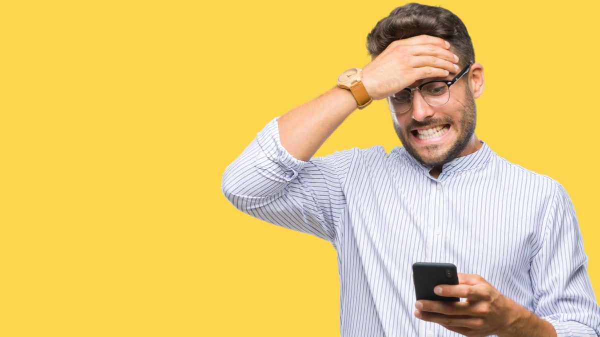 Falling ASX shares prices represented by scared male investor holding hand to head