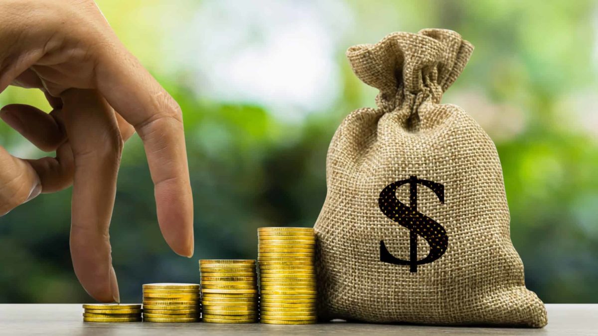 fingers walking up piles of coins towards bag of cash signifying asx dividend shares