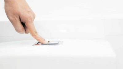 finger pressing flush button on toilet signifying falling gwa share price