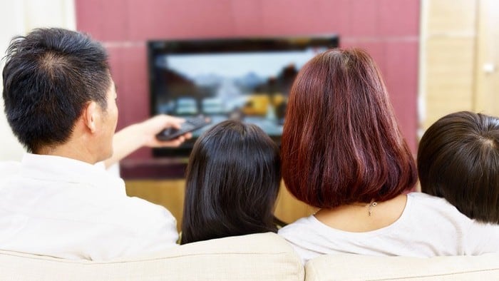 Family sitting together watching Netflix on TV