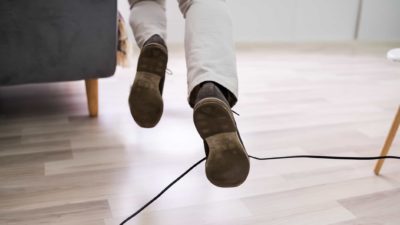 man tripping over electrical cable signifying falling origin share price