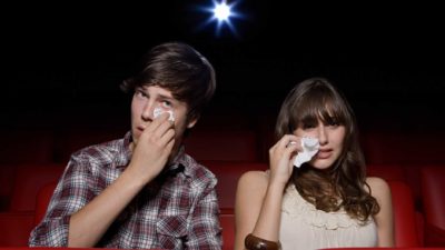 2 people sitting in a cinema crying representing falling village roadshow share price