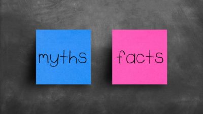 Blue post-it note with 'myths' written on it next to pink post-it note with 'facts' written on it