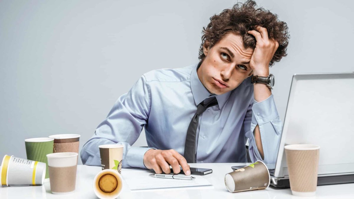 ASX 200 investor looking frustrated at falling share price whilst sitting at desk