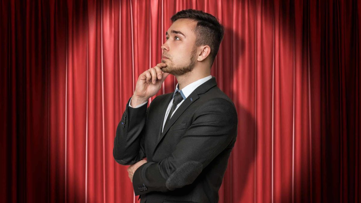 asx share stage set for advance represented by business man in spotlight in front of red curtain