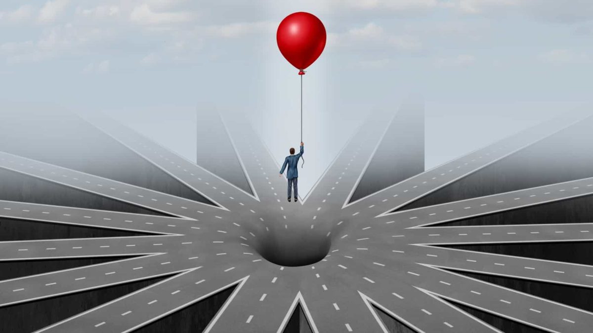 man suspended in air over hole in the road by holding a balloon representing pitfalls of infrastructure investments