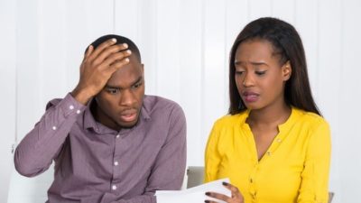 couple opening mail and looking distressed at contents representing market crash