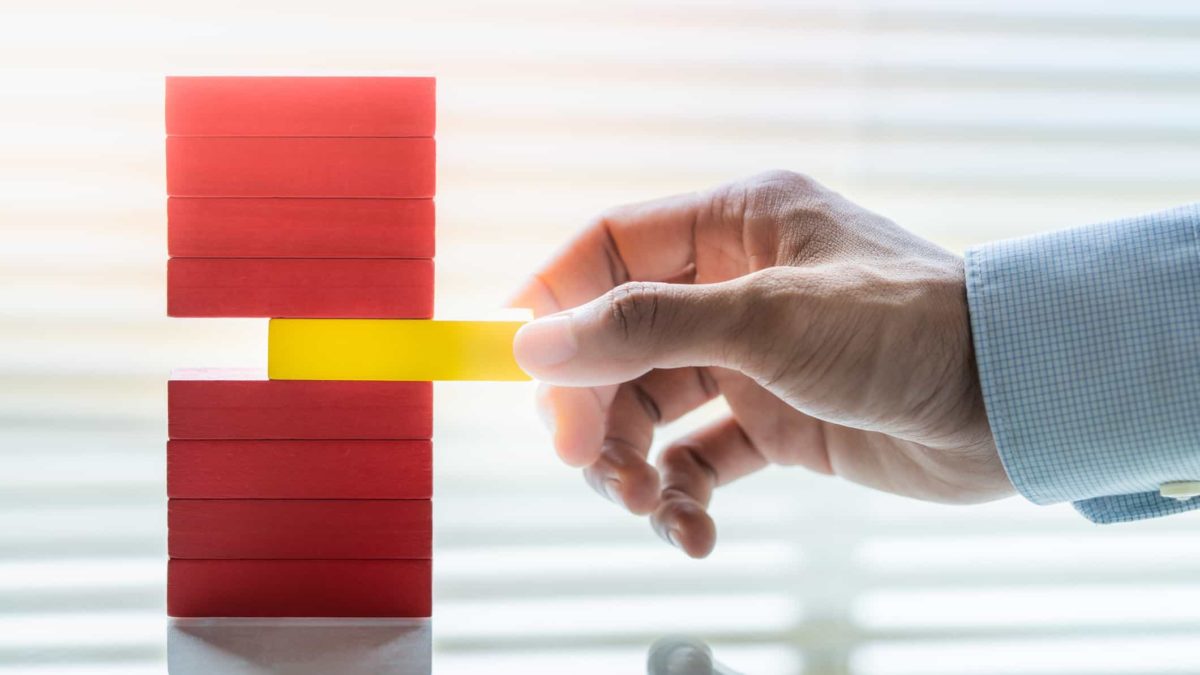 man about to pull middle block out of a pile of blocks